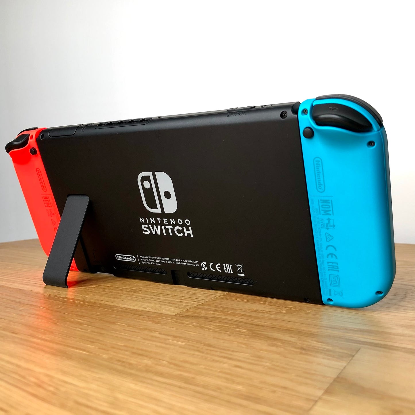 Back of Nintendo Switch console with Joy-Cons attached, showing logo, serial info, triggers and kickstand.