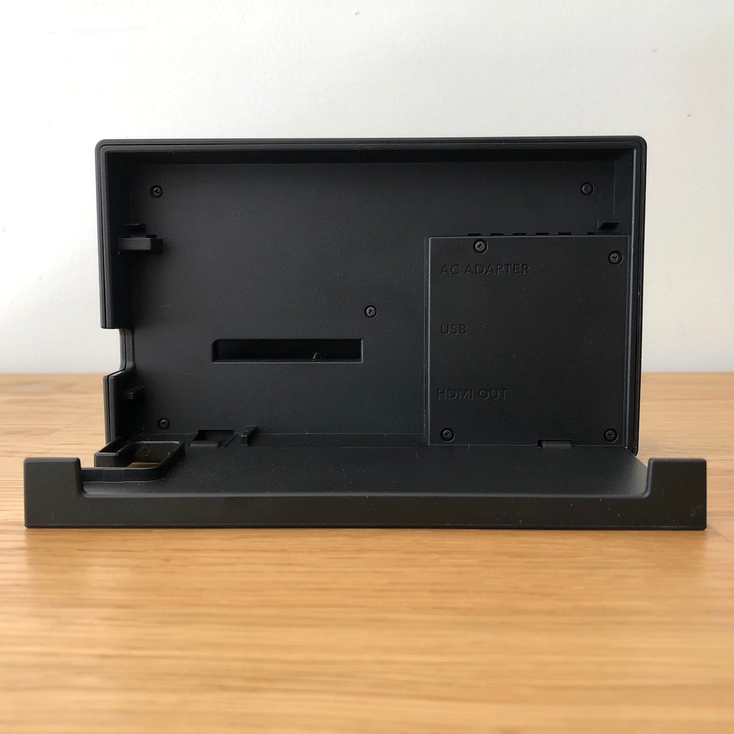 Inside of Nintendo Switch dock with flap open, showing ports for AC adapter, HDMI out and LAN.