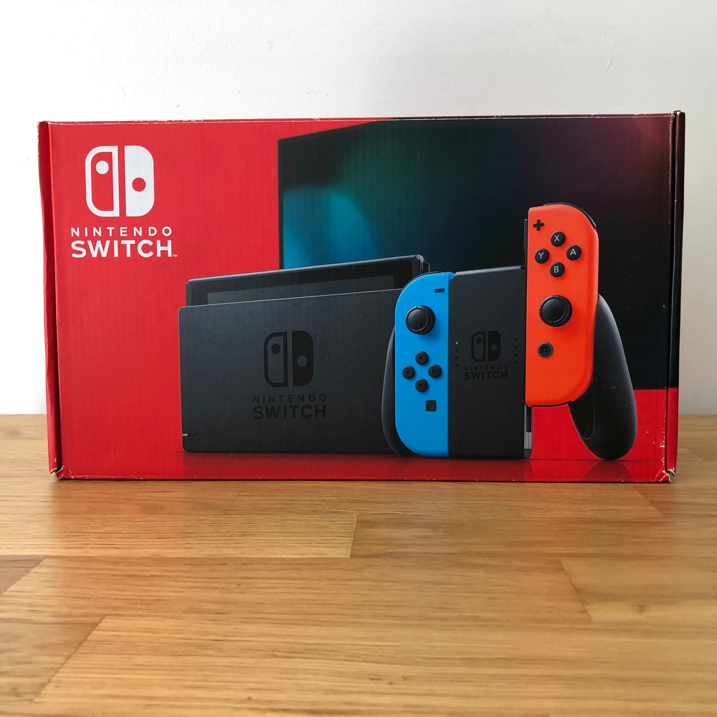 Front of Nintendo Switch box showing red and blue Joy-Cons with console, vibrant screen artwork and red packaging.