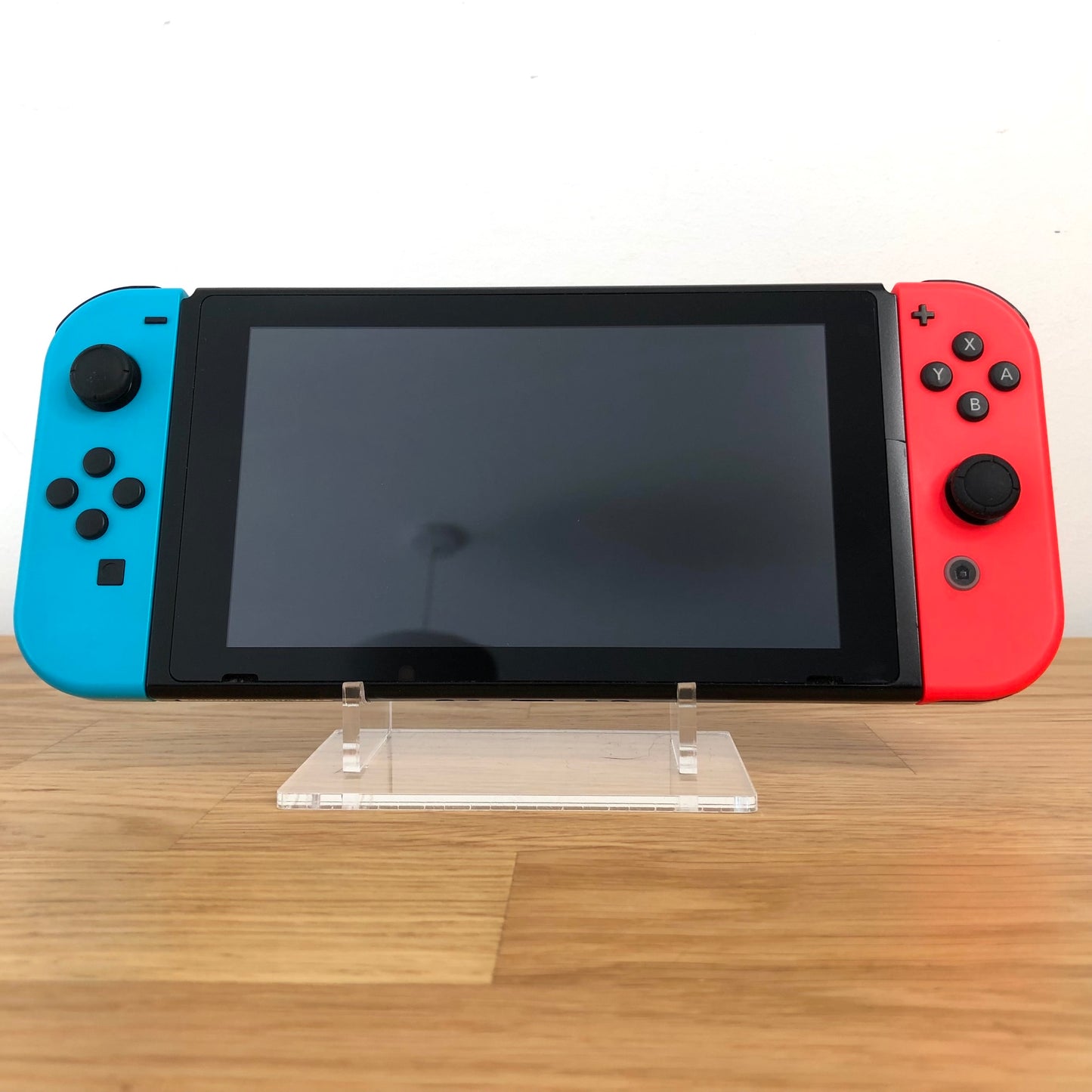 Front view of Nintendo Switch console with red and blue Joy-Cons attached, showing screen and face button layout.