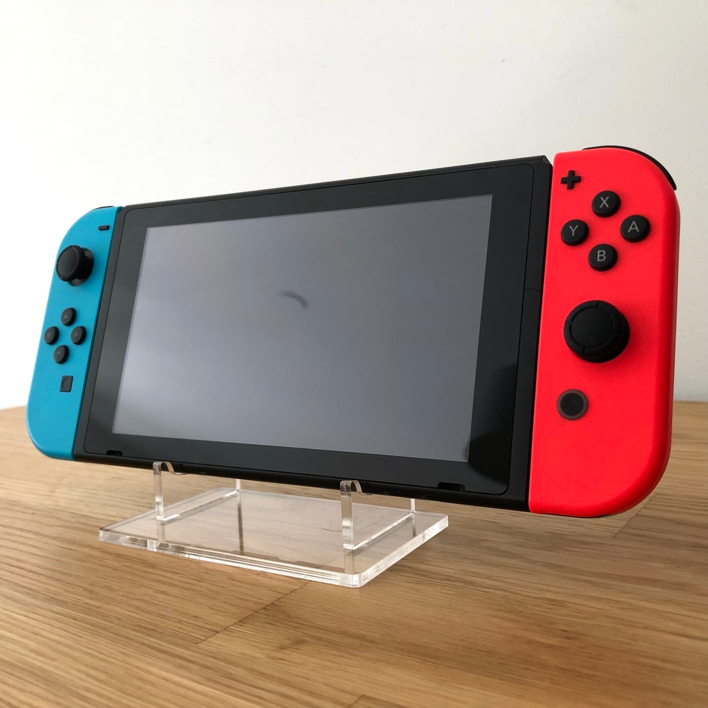 Angled front of Nintendo Switch with neon Joy-Cons, showing full face buttons, control sticks and screen.