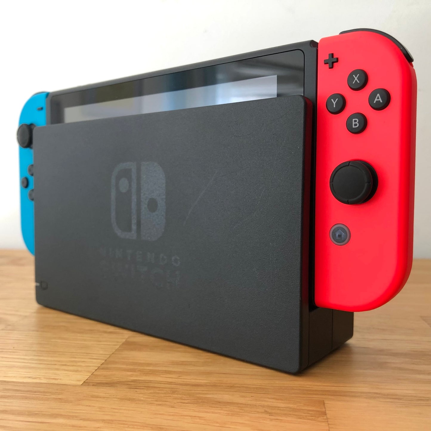 Angled right view of Nintendo Switch console docked with neon Joy-Cons, showing control sticks and front layout.