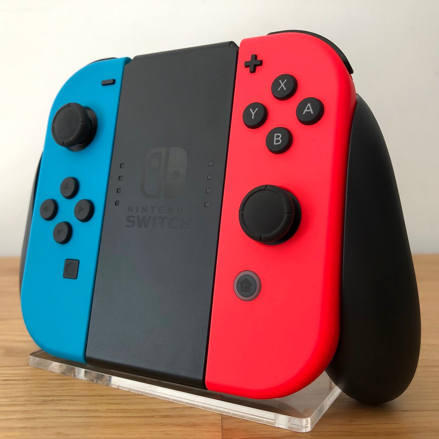 Angled right view of Joy-Con grip with neon Joy-Cons, showing all front facing buttons.