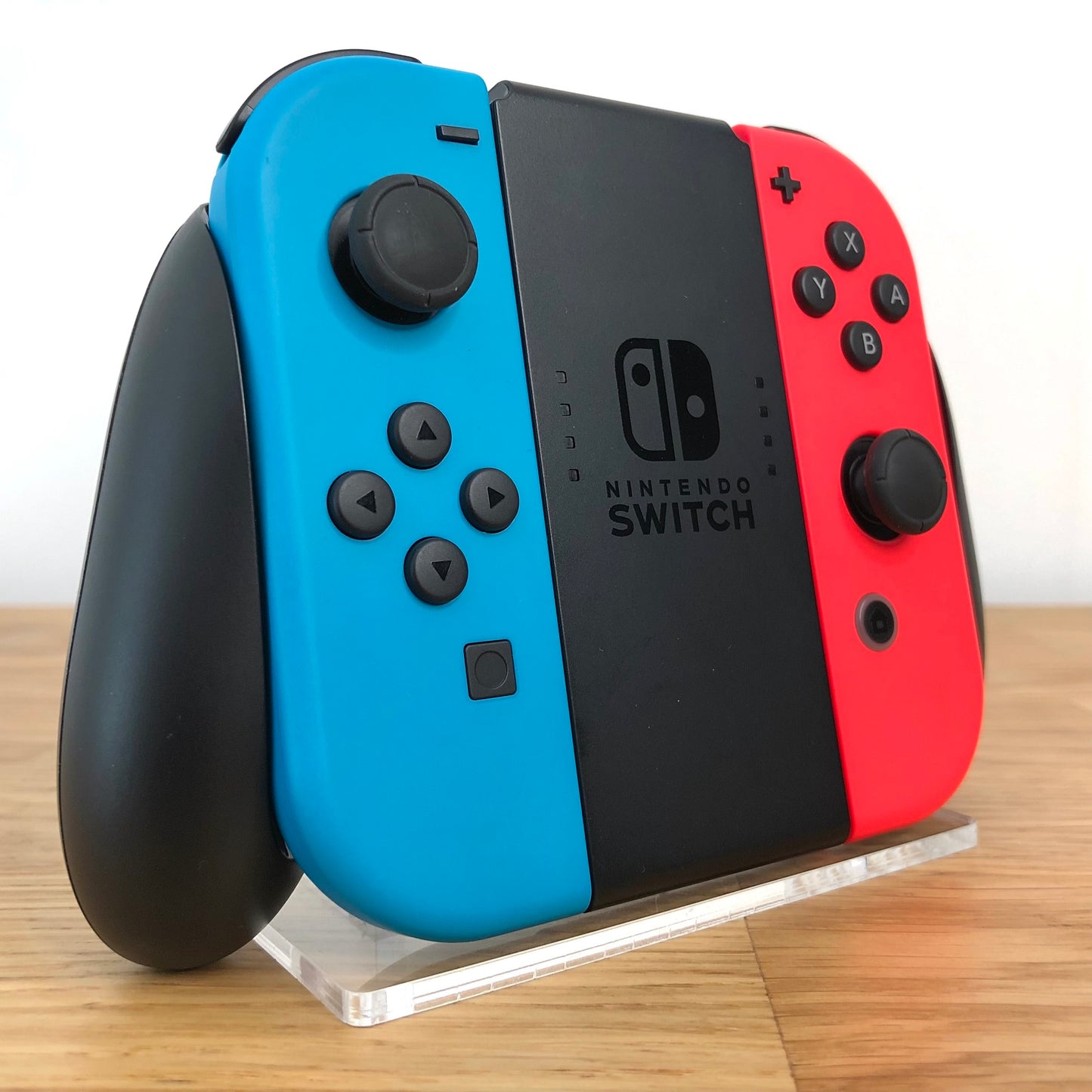 Angled left view of Joy-Con grip with neon Joy-Cons, showing all front facing buttons.