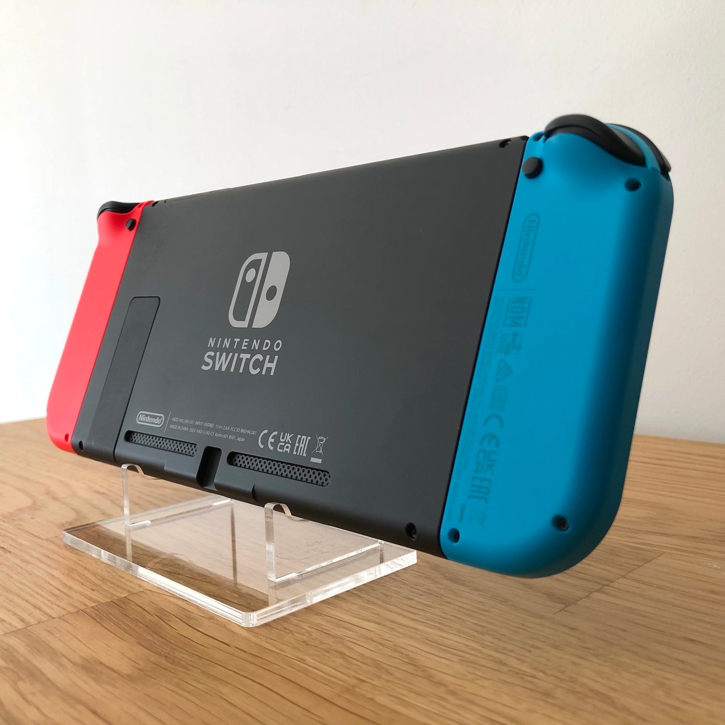 Angled front of Nintendo Switch with neon Joy-Cons, showing full face buttons, control sticks and screen.