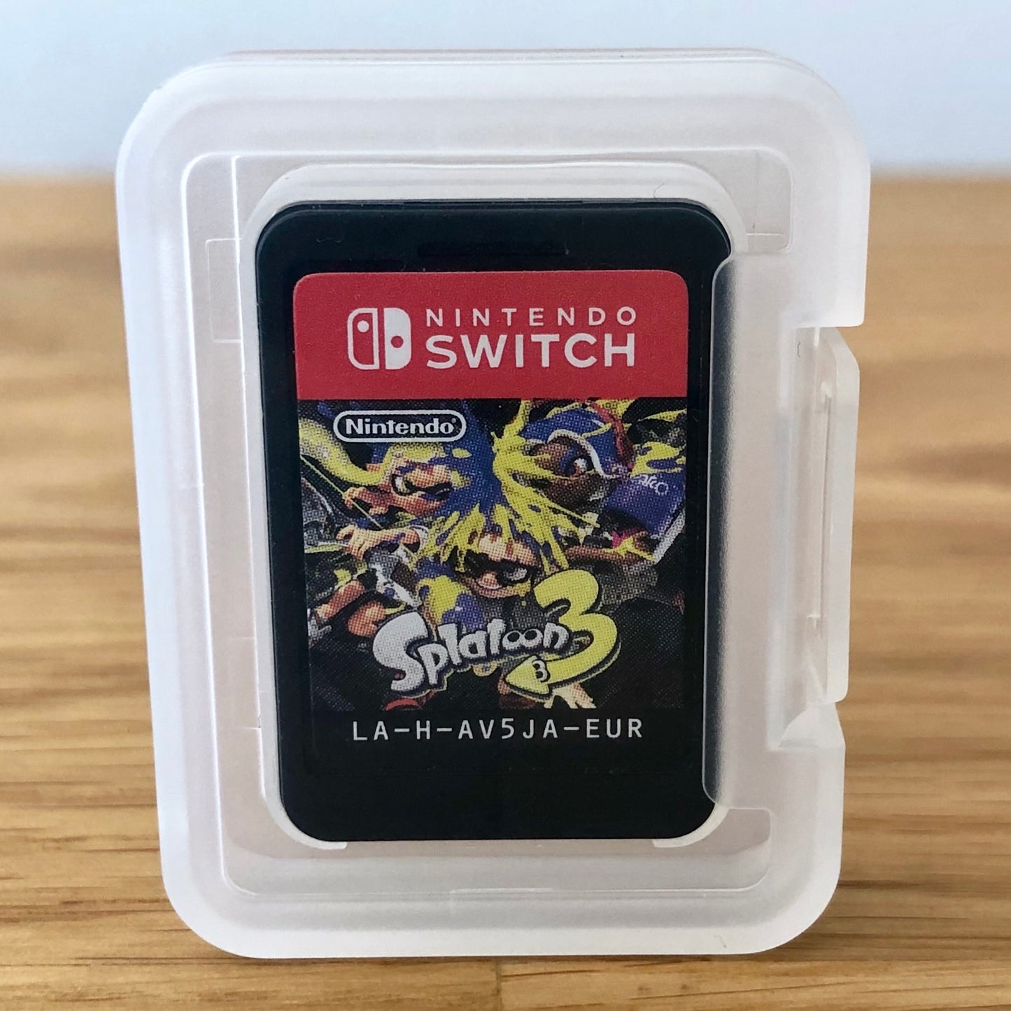 Splatoon 3 Nintendo Switch game cartridge inside a transparent protective case, front label visible through the case.