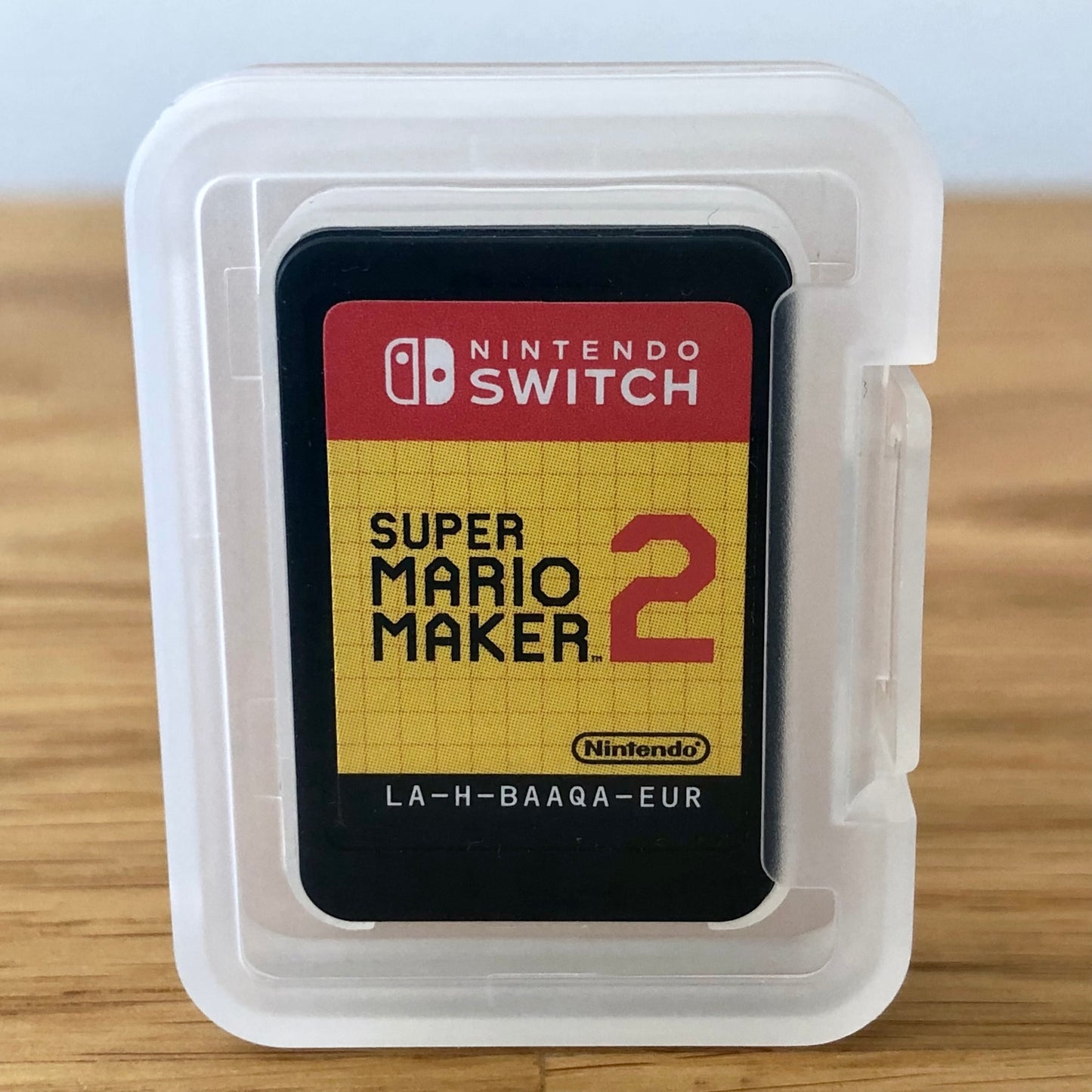 Super Mario Maker 2 Nintendo Switch game cartridge inside a transparent protective case, front label visible through the case.