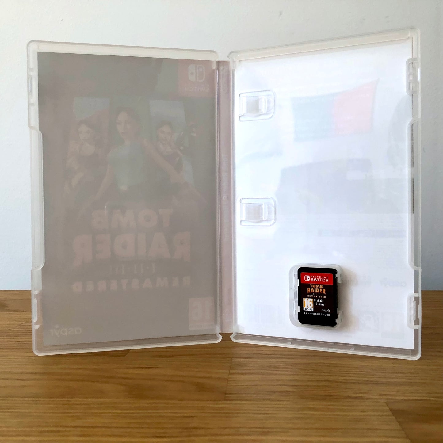 Inside the case of Tomb Raider I–III Remastered for Nintendo Switch, showing the cartridge and case design.