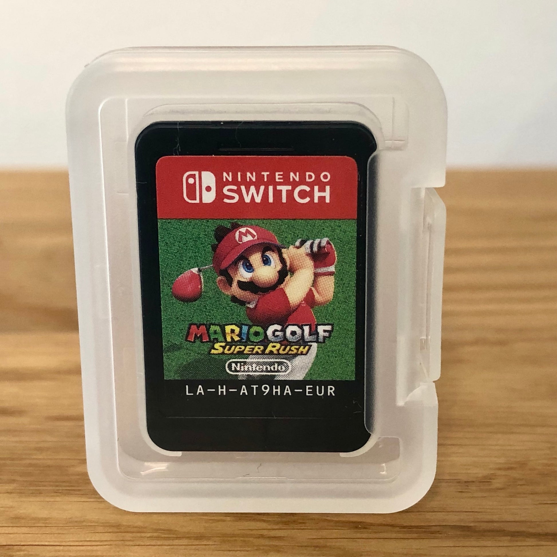 Cartridge of Mario Golf: Super Rush for Nintendo Switch, the cartridge is inside a cartridge size transparent protective case, through which you can see the front of the cartridge