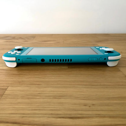 Top edge view of turquoise Nintendo Switch Lite with game card slot, headphone jack, vent, and shoulder buttons visible.