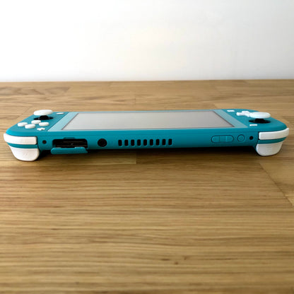 Flat top edge shot of turquoise Nintendo Switch Lite showing all buttons, ports, vent, and shoulder triggers in full view.