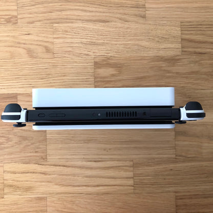 Top-down view of Nintendo Switch OLED in dock, showing Joy-Con triggers, game card slot and top-side buttons.
