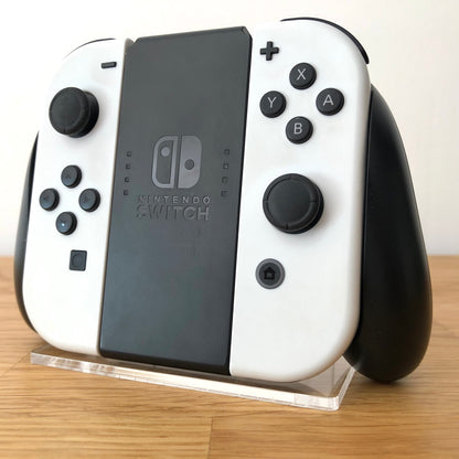 Angled view of Joy-Con grips for Nintendo Switch with white Joy-Cons attached, showing condition with all face buttons visible.