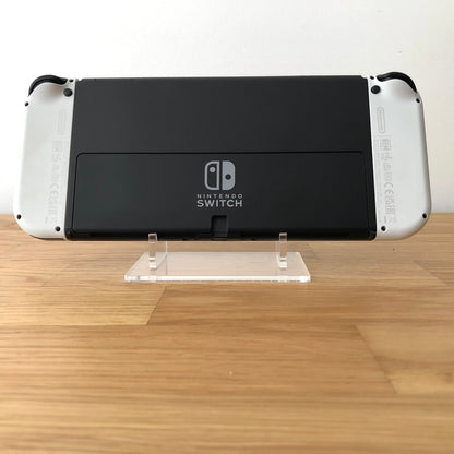 Back of Nintendo Switch OLED console with white Joy-Cons attached, showing logo and rear casing detail.