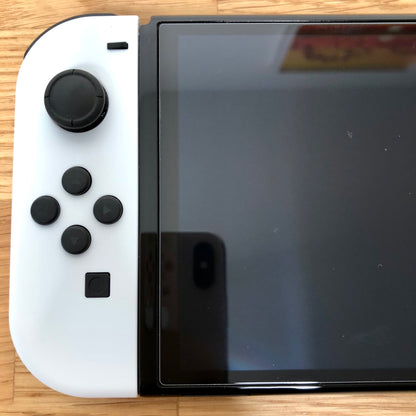 Close-up of white left Joy-Con on Nintendo Switch OLED, showing D-pad style buttons, left stick and minus button.