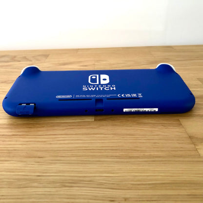Angled bottom view of blue Nintendo Switch Lite console showing charging port, serial number and microSD slot.