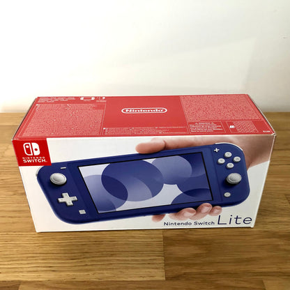 Front of Nintendo Switch Lite box in blue, showing product artwork and branding on a clean wooden surface.