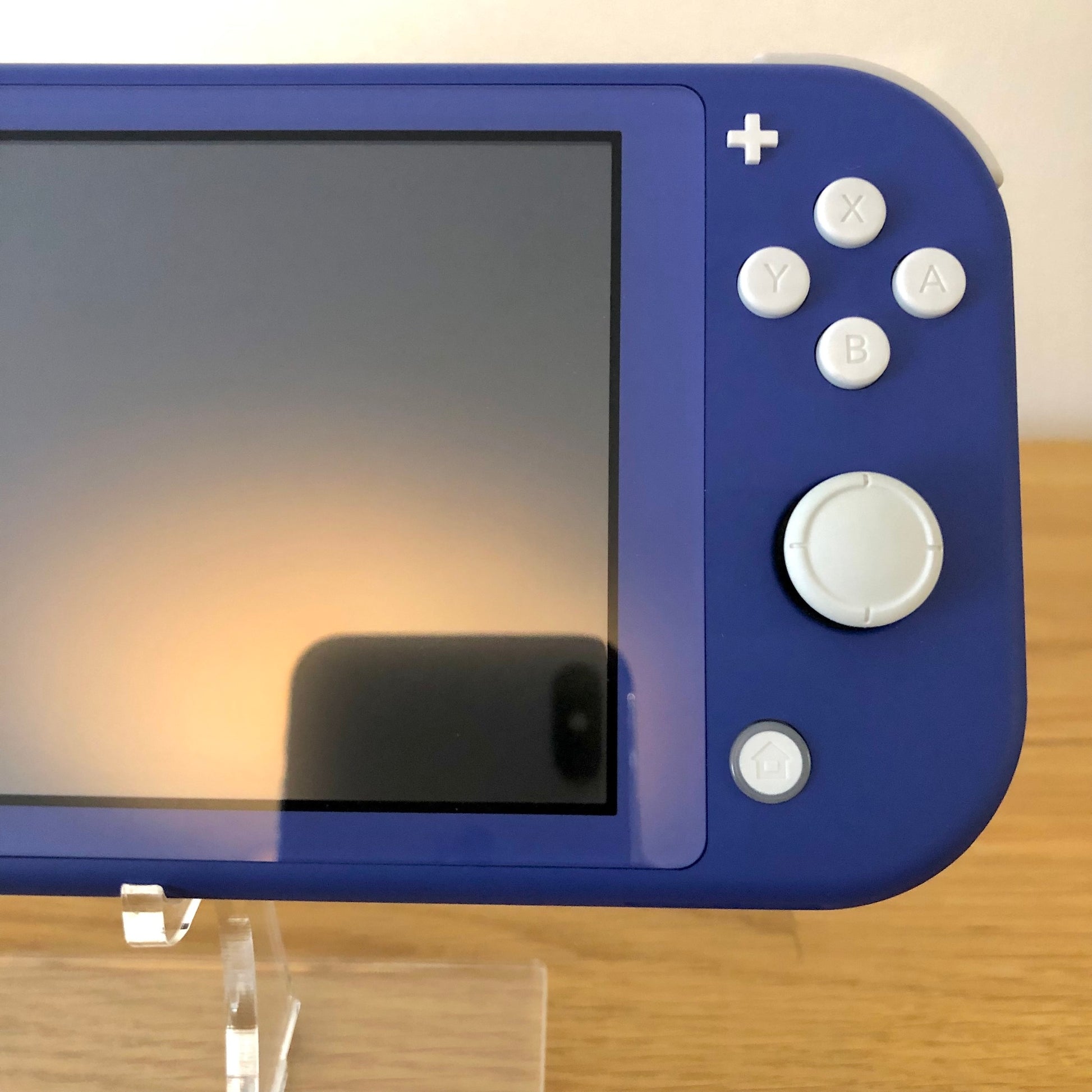 Close-up of right side controls on blue Nintendo Switch Lite including A, B, X, Y and home button.